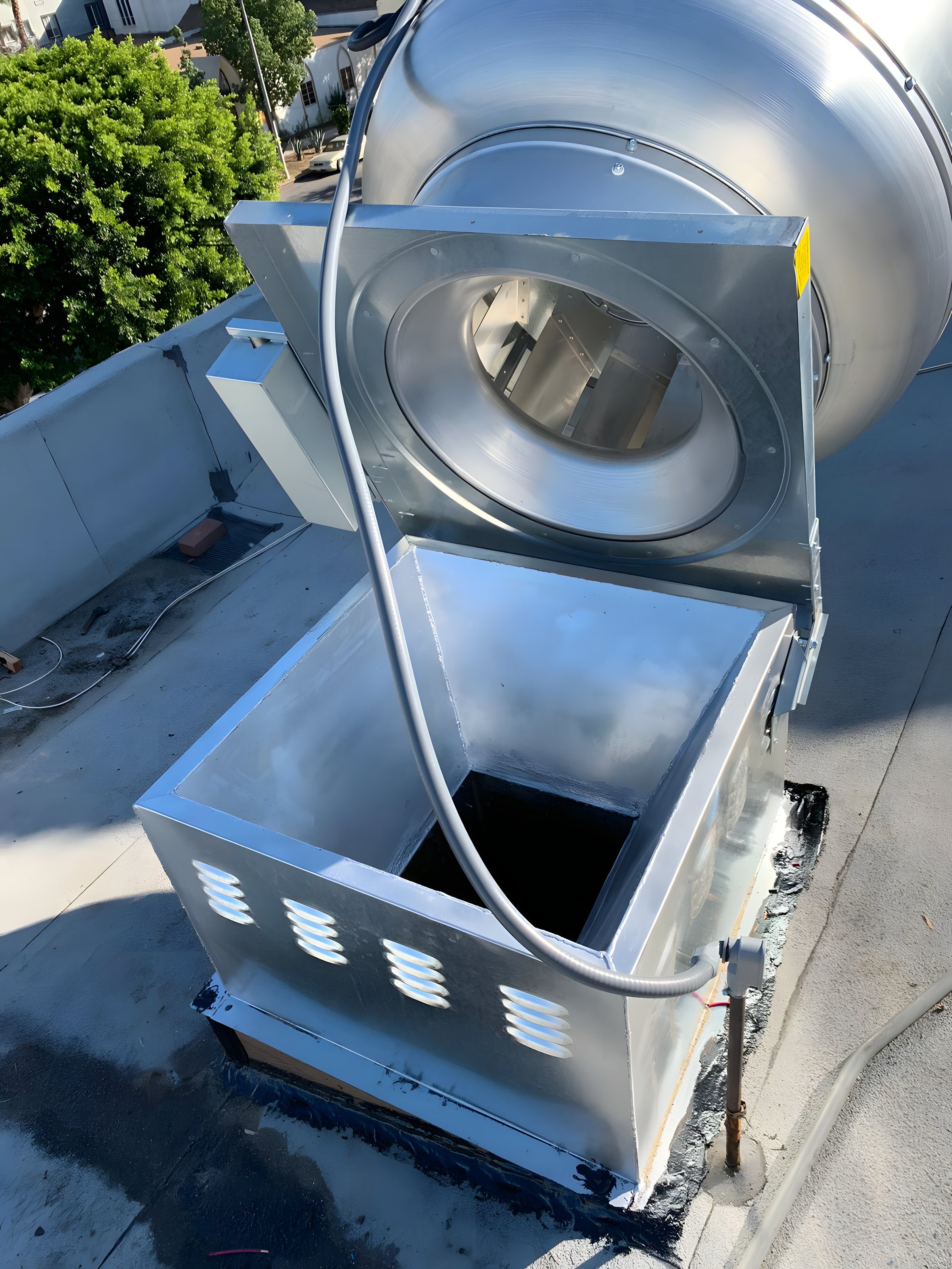 A rooftop exhaust fan opened up for service